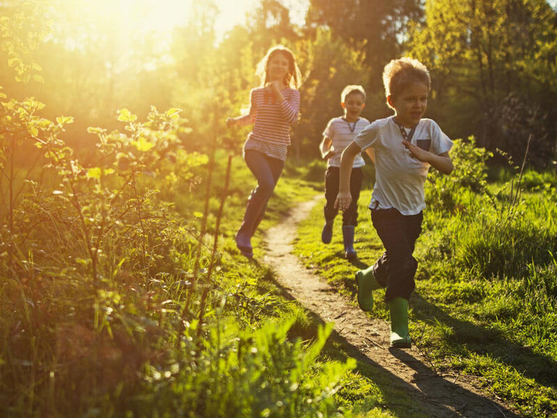 Three children running outside
